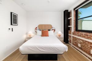 a bedroom with a bed and a brick wall at The Brick Boutique Hotel in Oceanside