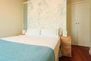 a bedroom with a bed with a blue and white wall at Madeinterranea Apartments in Málaga