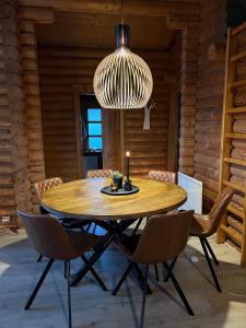 una sala da pranzo con tavolo in legno e lampadario pendente di Cosy cabin with amazing view on the Geysir a Blaskogabyggo