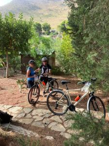 dos personas están de pie junto a sus bicicletas en Baglio La Luna - B&B, en San Vito lo Capo