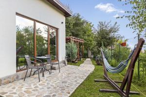 a patio with a hammock and a table and chairs at Silver Bungalow in Săcele
