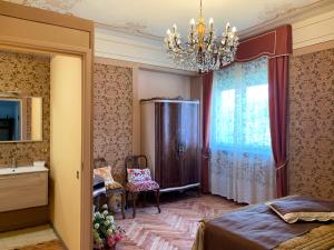 a bedroom with a bed and a chandelier at Villa Delbia - L'Elfo in Candelo