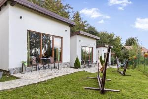 a white house with a patio and grass at Silver Bungalow in Săcele