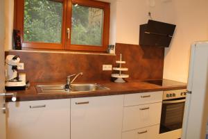 a kitchen with white cabinets and a sink and a window at Waldblick in Baiersbronn