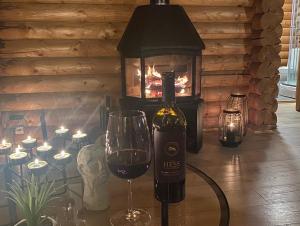 eine Flasche Wein und ein Glas auf dem Tisch mit Kamin in der Unterkunft Cosy cabin with amazing view on the Geysir in Blaskogabyggo