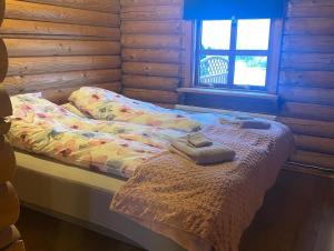 Una cama en una cabaña de madera con dos toallas. en Cosy cabin with amazing view on the Geysir, en Blaskogabyggo