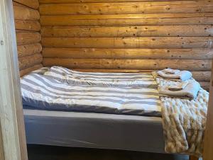 Una cama en una cabaña de madera con toallas. en Cosy cabin with amazing view on the Geysir en Blaskogabyggo