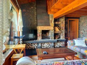 a living room with a stone fireplace and a couch at Cal Ferrer del Querforadat in Cava