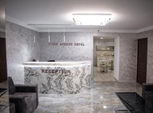 a room with a kitchen with a counter and chairs at Opera Avenue Hotel in Yerevan