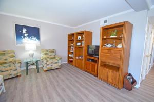 a living room with a tv and a couch and a chair at Our Place At The Beach 105E Condo in Ocean City