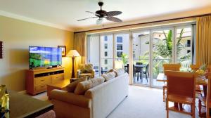 a living room with a couch and a flat screen tv at Honua Kai - Hokulani 414 in Lahaina