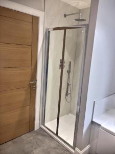 a shower in a bathroom with a glass door at Anne's Place in Boat of Garten