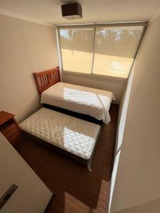 Habitación pequeña con cama y ventana en Departamento 2P 2B para 4 personas By Terrabahía en Copiapó