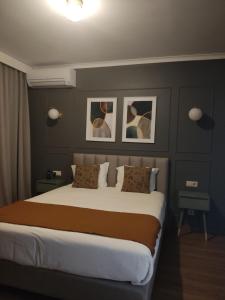 a bedroom with a large bed with two pictures on the wall at Hotel Rural Solar das Arcadas in Ponte de Lima