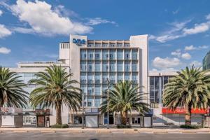 a hotel with palm trees in front of it at One Ciudad de Mexico Alameda in Mexico City