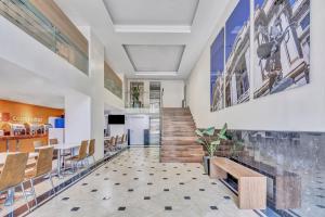 a lobby of a restaurant with a staircase and tables and chairs at One Ciudad de Mexico Alameda in Mexico City