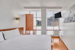 a bedroom with a bed and a large window at One Ciudad de Mexico Alameda in Mexico City