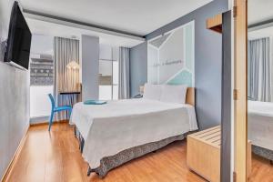 um quarto de hotel com uma cama e uma televisão em One Ciudad de Mexico Alameda em Cidade do México