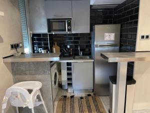 eine kleine Küche mit Kühlschrank und Spüle in der Unterkunft Le sacré cœur in Paris