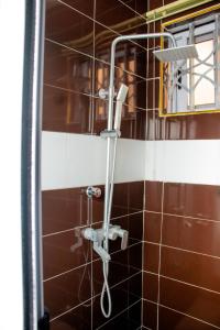 eine Dusche mit Duschkopf im Bad in der Unterkunft El-King Home Lodge in Afwerasi