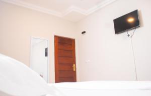 a bedroom with a tv on the wall and a bed at El-King Home Lodge in Afwerasi +26 photos