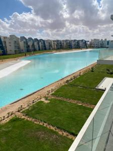 una gran piscina con edificios en el fondo en Fouka bay luxurious chalet, en Marsa Matruh