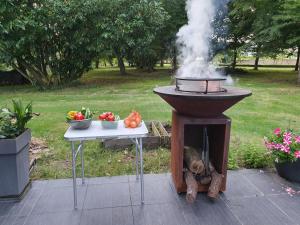 una parrilla con humo saliendo de ella junto a una mesa en Propriété de campagne, en Vierzon