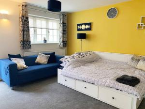 a bedroom with a bed and a blue couch at Park View Annexe 