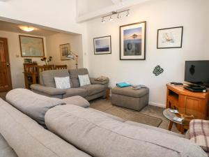 sala de estar con sofá y TV en Little Westwards, en Penzance