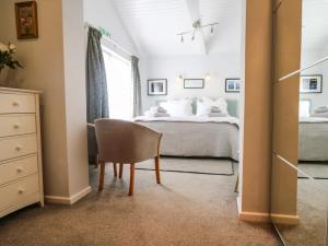 1 dormitorio con 1 cama y 1 silla en Little Westwards, en Penzance