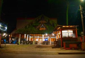 a restaurant with a grass roof at night at Mama Lira in Coveñas