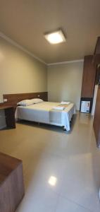 ein Schlafzimmer mit einem großen Bett in einem Zimmer in der Unterkunft Pousada Dom Quixote in São João da Barra