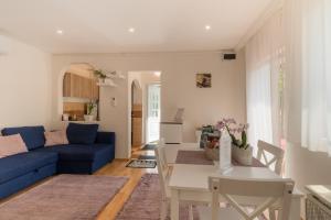 a living room with a blue couch and a table at Lianne Apartman in Miskolctapolca