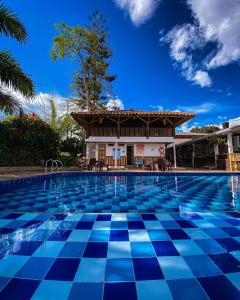 a swimming pool in front of a house with a building at Eco Hotel las Palmas in Armenia