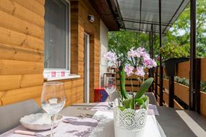 einen Tisch mit zwei Gläsern und eine Vase Blumen in der Unterkunft Lianne Apartman in Miskolctapolca