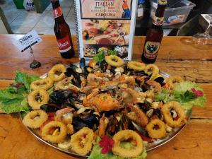 a plate of seafood on a table with two bottles of beer at Cabinas Carolina in Puerto Jiménez