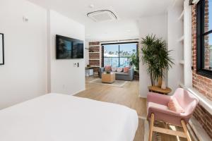 a bedroom with a bed and a living room at The Brick Boutique Hotel in Oceanside