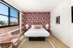 a bedroom with a bed and two chairs at The Brick Boutique Hotel in Oceanside