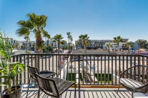 a balcony with chairs and palm trees and a city at The Brick Boutique Hotel in Oceanside