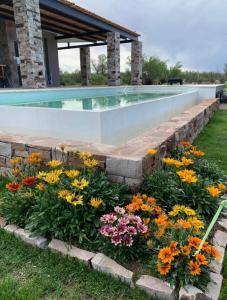 a retaining wall around a swimming pool with flowers at Casa Pueblo Benegas in San Rafael