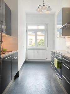 una cocina con armarios negros y una ventana en Bezaubernde Wohnung in zentraler Lage, en Karlsruhe