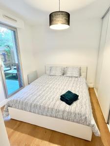 Un dormitorio con una cama con una bolsa verde. en Deux pièces cosy à La Croisette, en Carrières-sous-Poissy