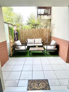 a patio with two couches and a table at Deux pièces cosy à La Croisette in Carrières-sous-Poissy