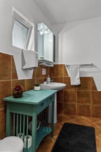 ein Badezimmer mit einem Waschbecken, einem WC und einem Spiegel in der Unterkunft Casa Georgea in Săcele