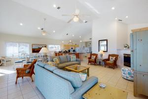 a living room with two blue couches and a kitchen at Beach Boy in St. George Island