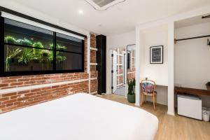 a bedroom with a brick wall and a large window at The Brick Boutique Hotel in Oceanside