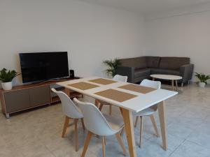a table and chairs in a living room with a tv at Alojamientos Litoral - 1 B in Gualeguaychú