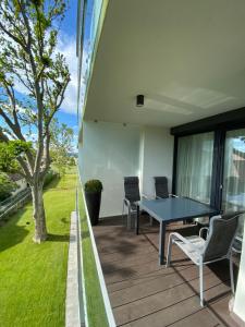 eine Terrasse mit einem Tisch und Stühlen auf einer Terrasse in der Unterkunft Premium Lelle Waterfront Resort Clyde in Balatonlelle