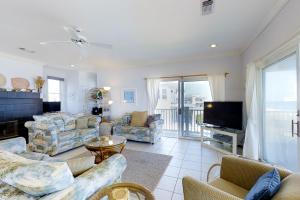 a living room with couches and a tv at King's Crown in St. George Island