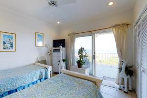 a bedroom with two beds and a large window at King's Crown in St. George Island